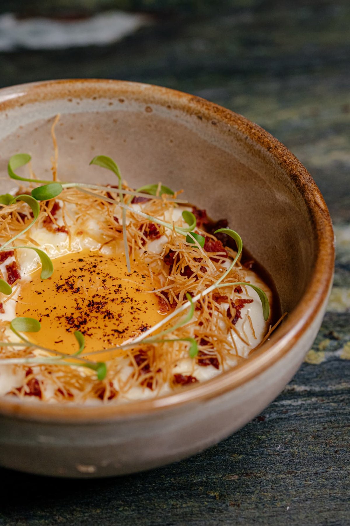 Egg yolk dish with sunflower shoots in a ceramic bowl